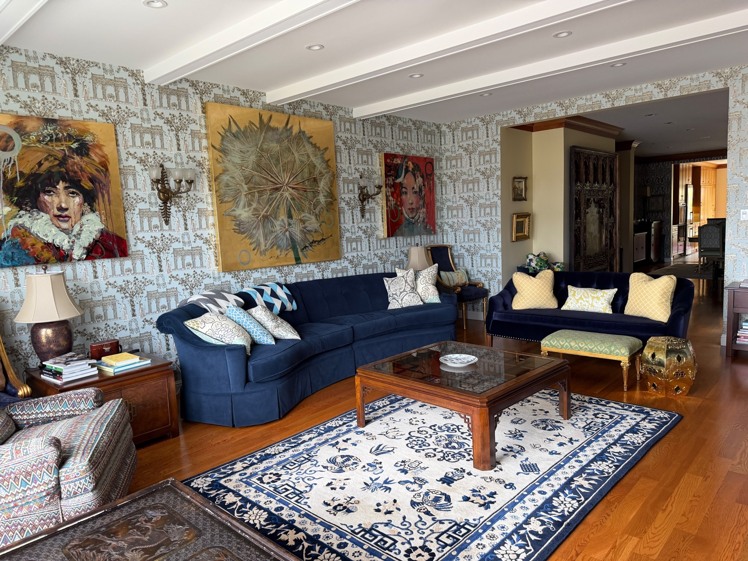 Formal living room with blue sofas, artwork and hardwood floors